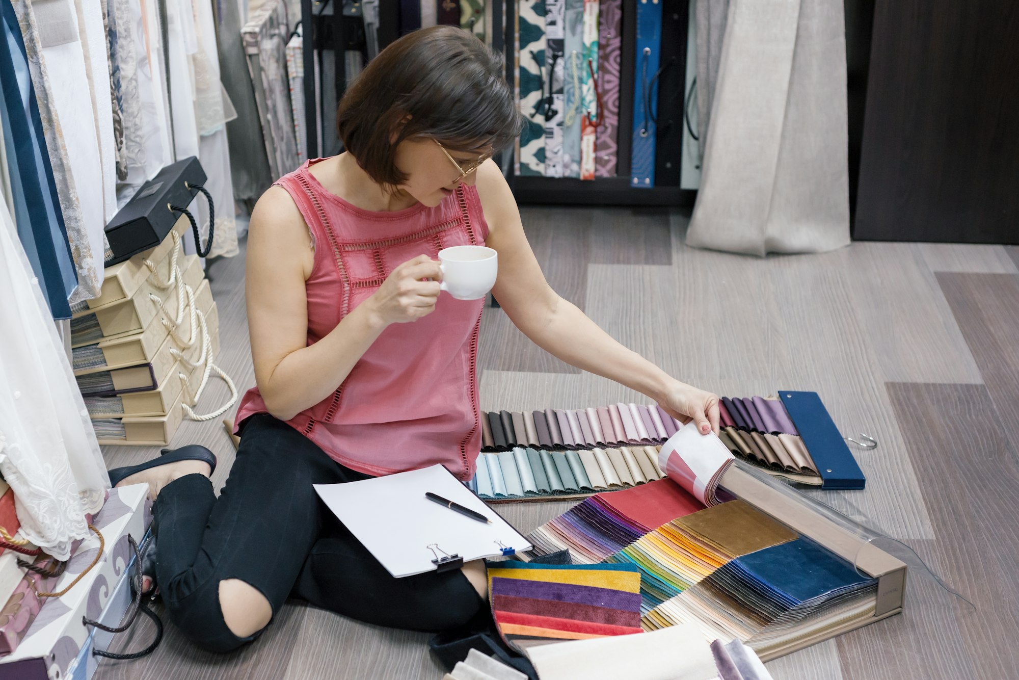 Fabrics store, female designer chooses fabrics for interior decoration